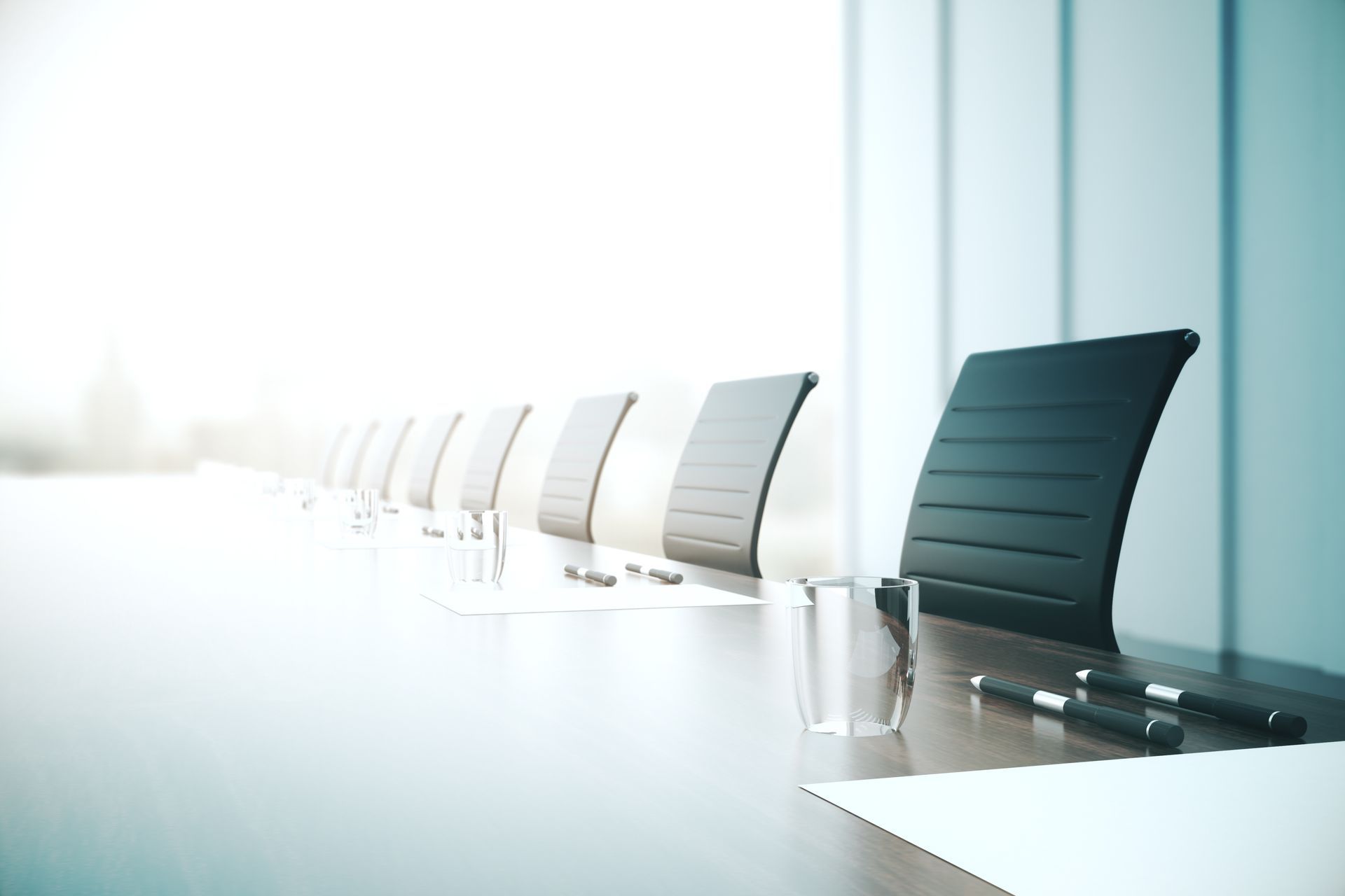 A bright conference room with a long meeting table.